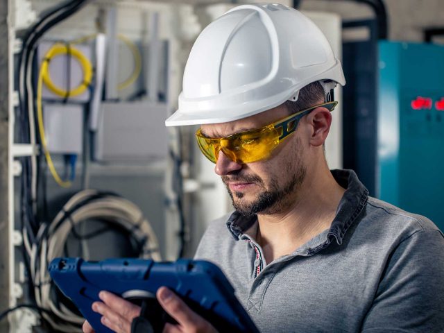 man-an-electrical-technician-working-in-a-switchbo-J8LUJ4C.jpg
